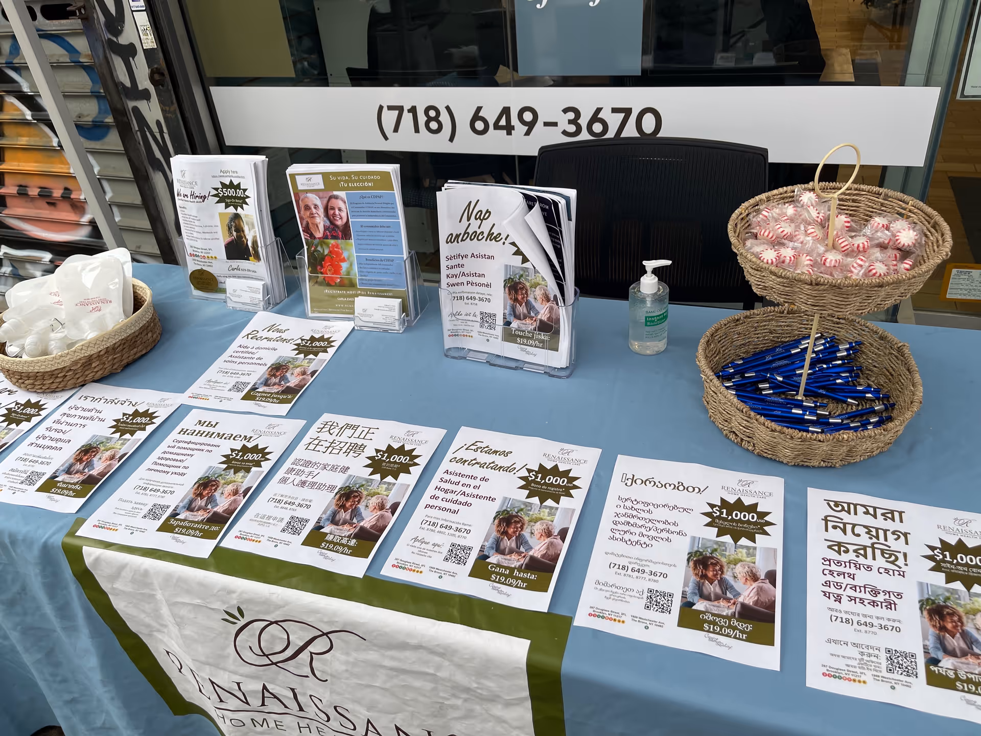 Table with brochures, hand sanitizer, and candy canes at Renaissance Home HC outreach booth.