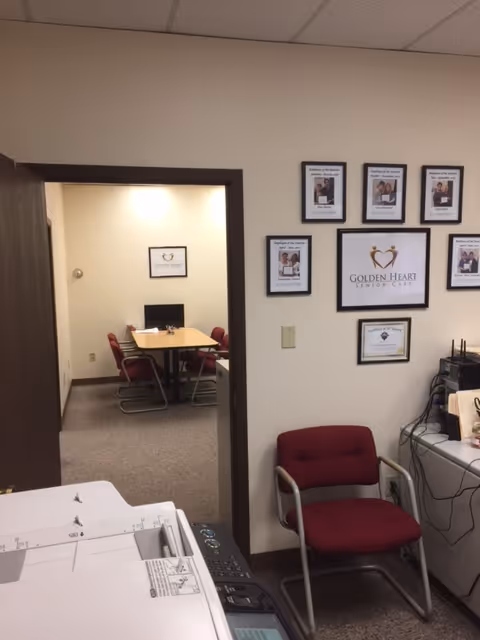 Office reception area inside Golden Heart Home Care with framed certificates and a doorway.