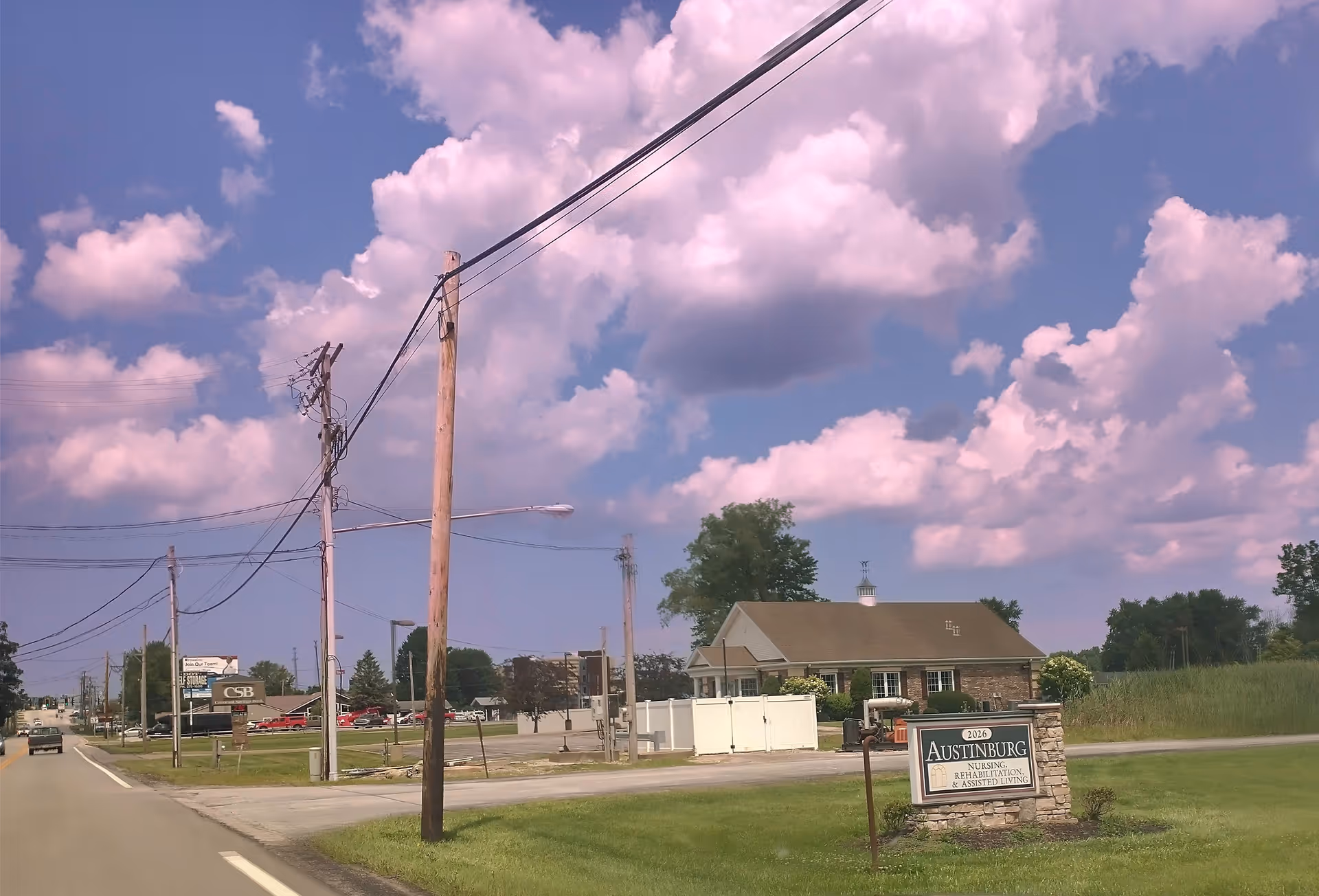 Exterior view of Austinburg Nursing Home & Rehabilitation Center with a road sign.