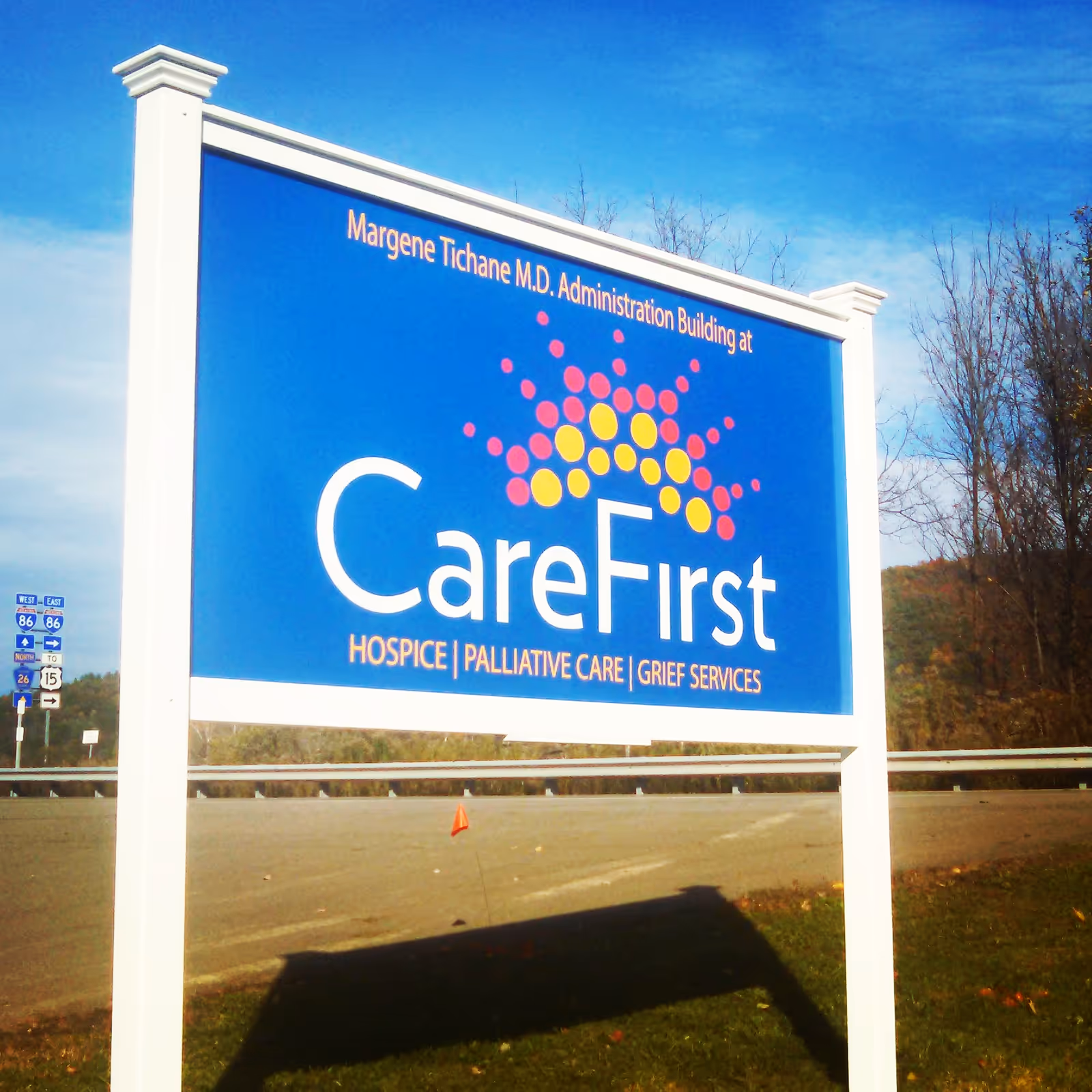 Large blue CareFirst sign on a white frame beside a highway.