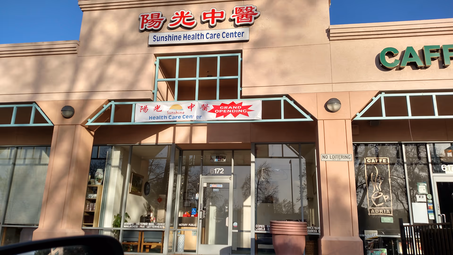 Front exterior of Sunshine Health Care Center with glass doors and banners.