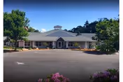 Front view of Spring Meadows Assisted Living Community, a single-story building with parking and landscaping.