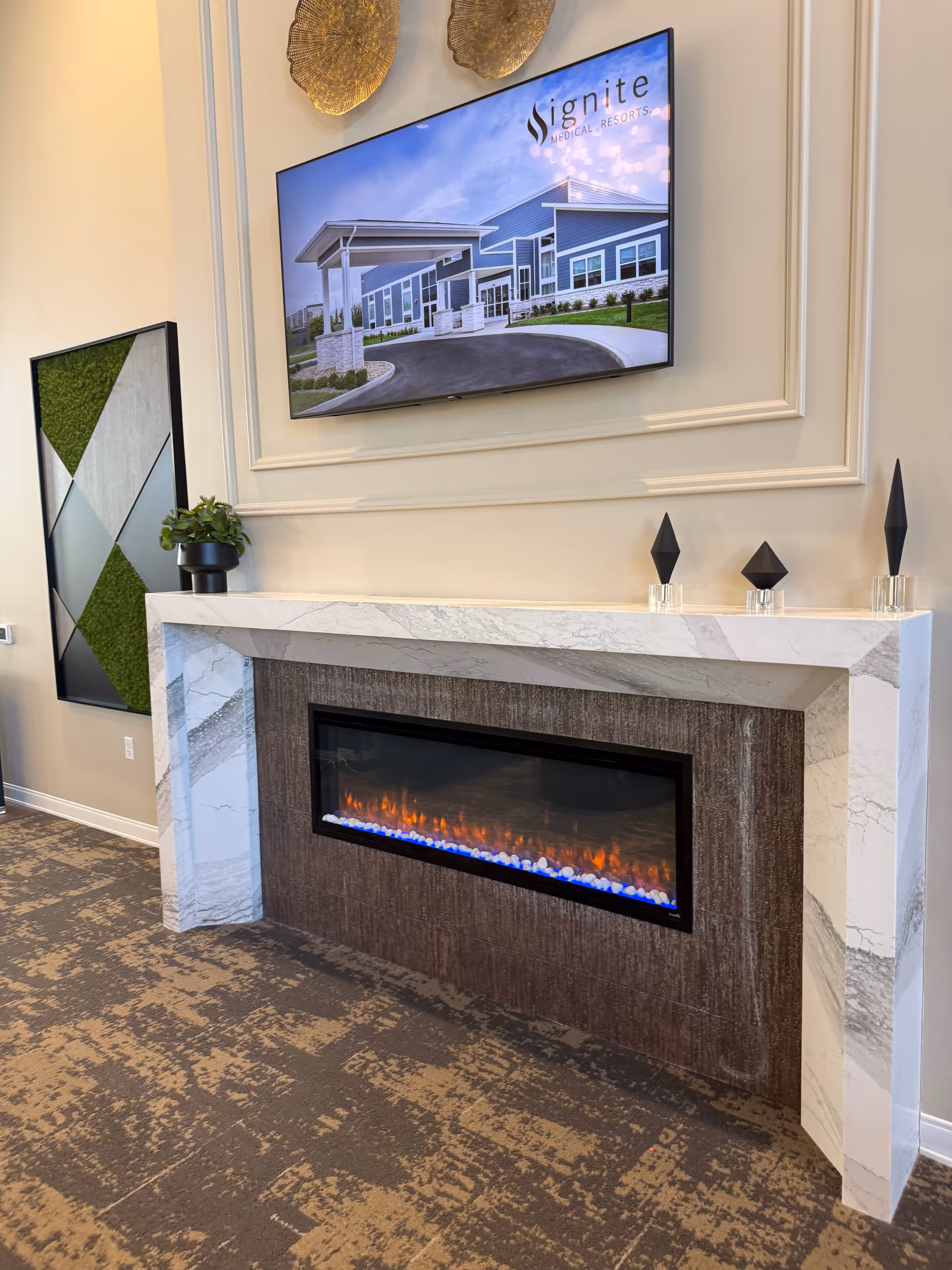 Modern living room area with a marble fireplace and mounted Ignite Medical Resorts TV.