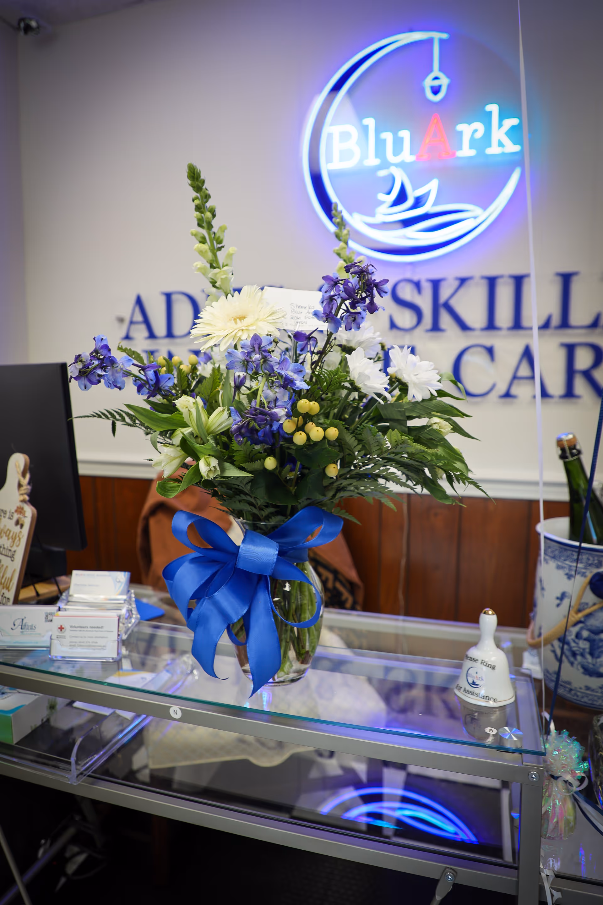Interior reception area featuring a flower bouquet and BluArk neon sign.