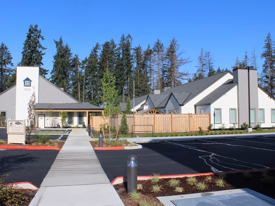 Exterior view of The Cottages of Covington with a walkway and parking.