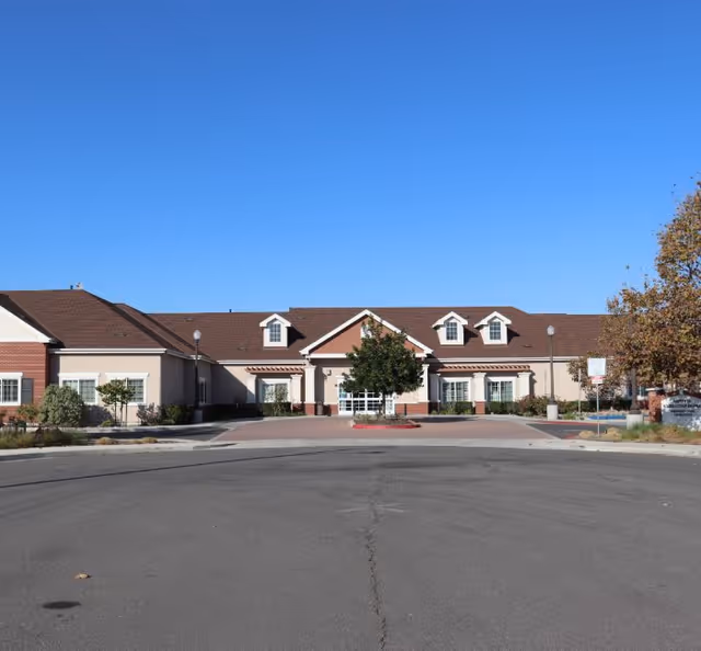 Exterior view of Artesia Christian Home building with parking lot and clear blue sky.