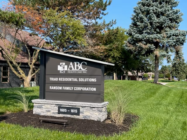 Outdoor sign for ABC Health Care Inc on a grassy lawn with trees