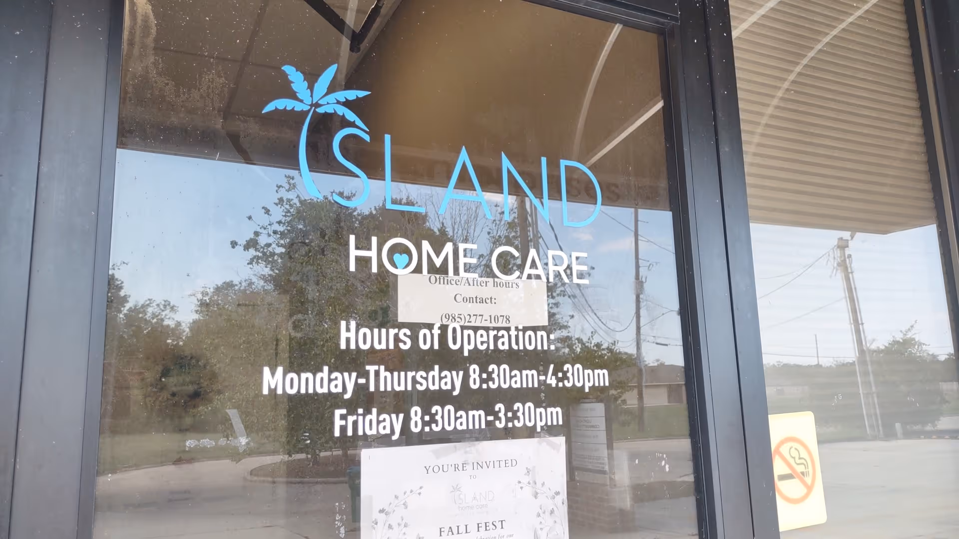 Storefront glass door with Island Home Care logo and hours displayed.