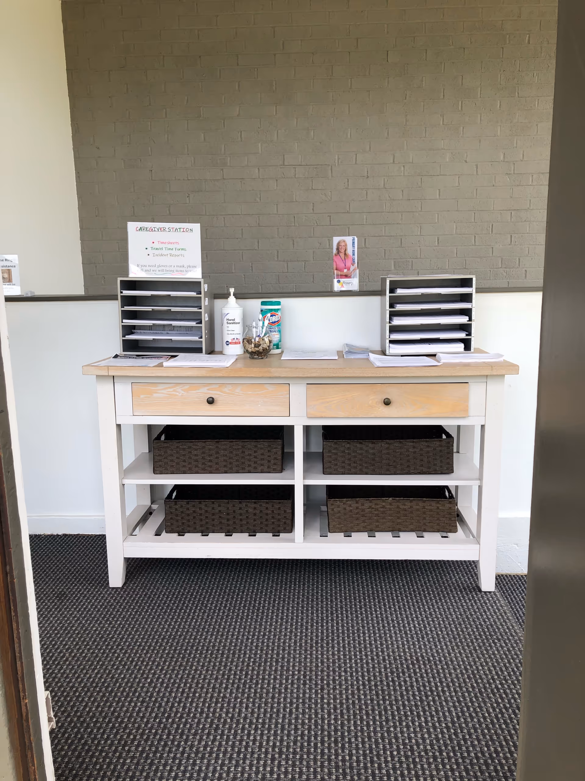 A wooden reception desk with drawers and open shelves against a gray wall.