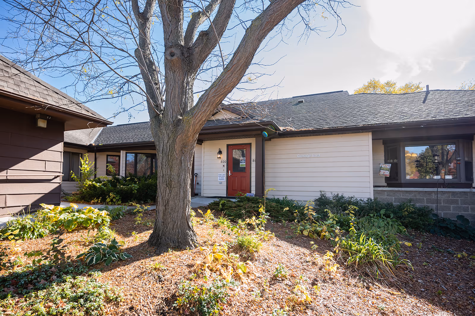 Exterior view of Cottage East by Three Links, showing the entrance and landscaped front yard.