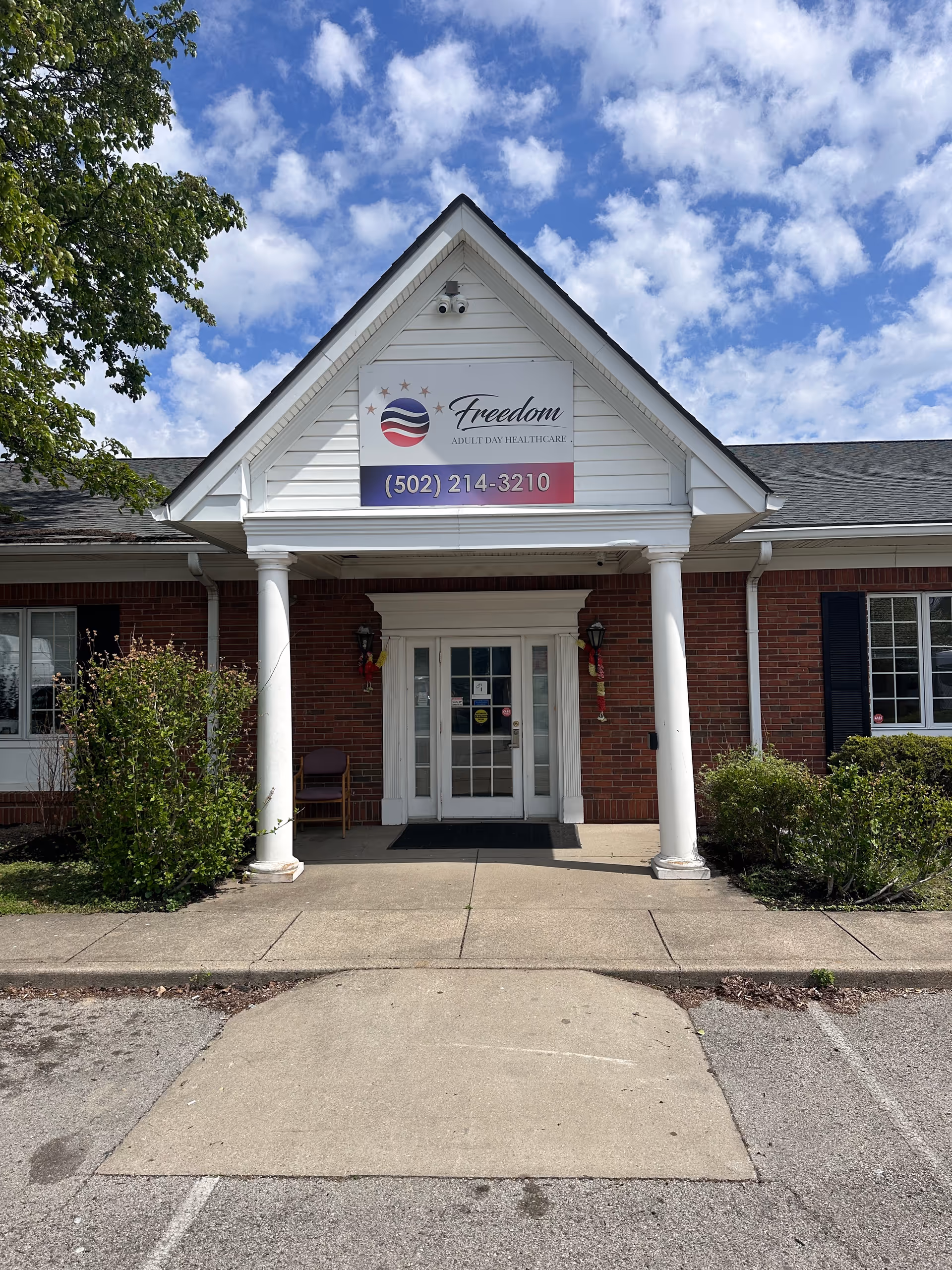 Front entrance of the Freedom Senior Services building with brick exterior and white pillars.