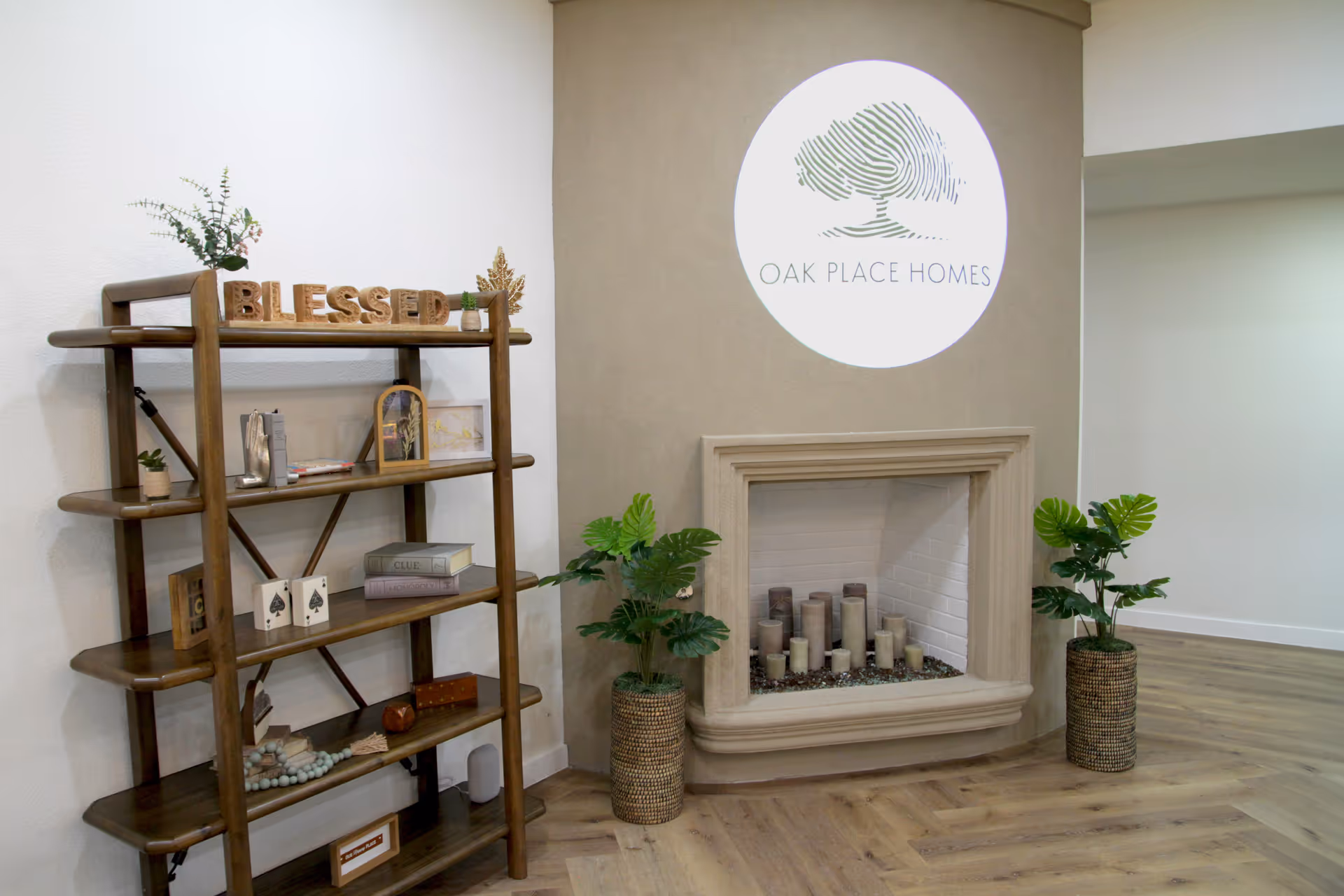 Interior lobby featuring a fireplace, Oak Place Homes logo, and a wooden display shelf.