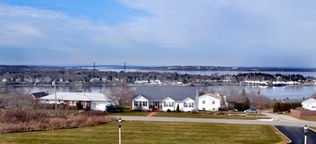 Exterior view of Brookdale Sakonnet Bay by the water with lawns.