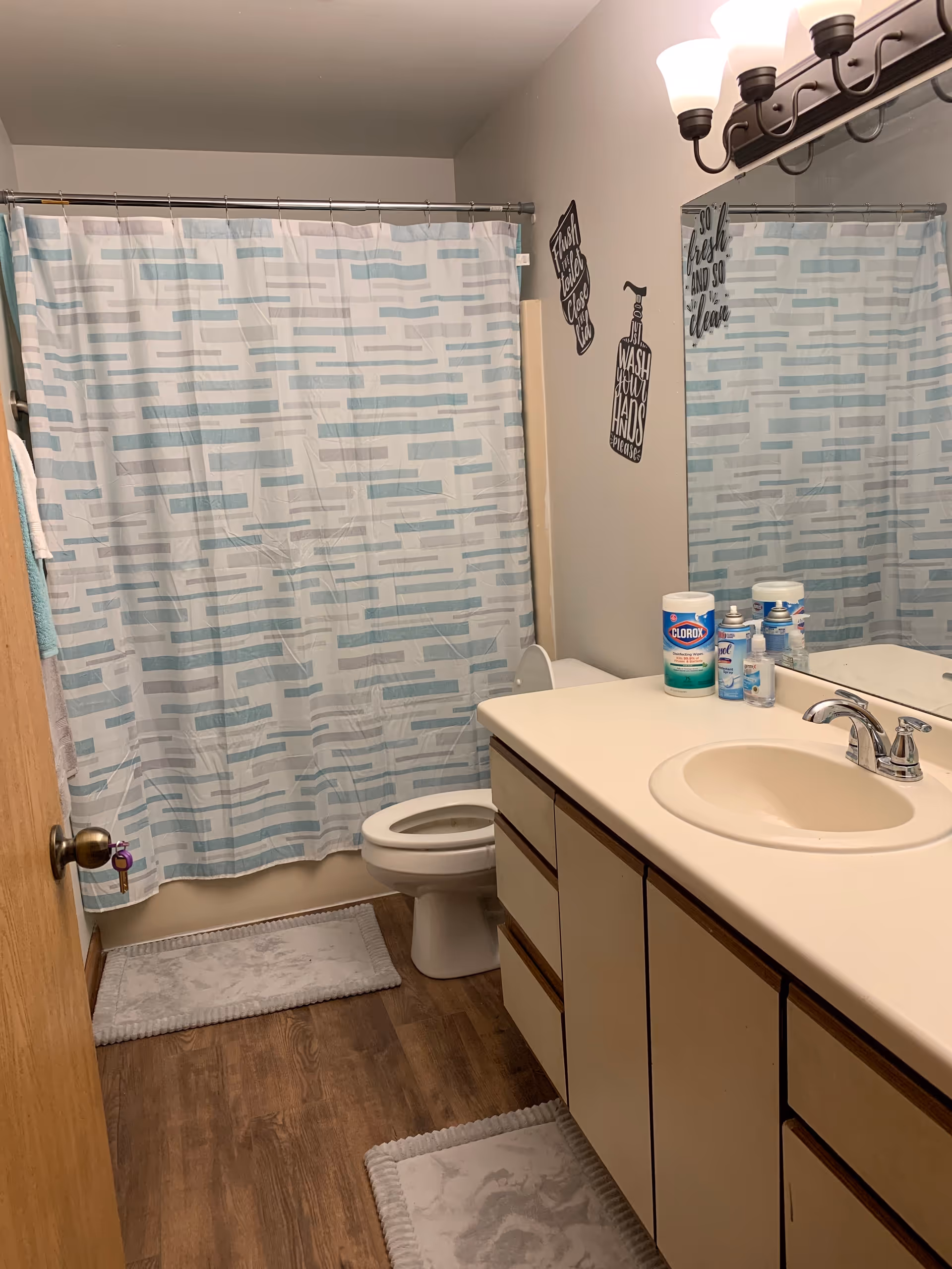 Bathroom in a senior living home featuring a blue striped shower curtain and sink.