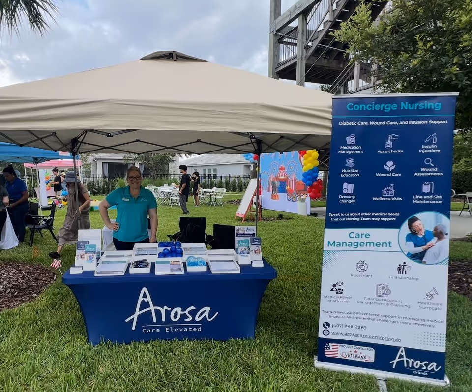 Arosa Orlando outdoor booth under a beige tent with staff promoting care services.