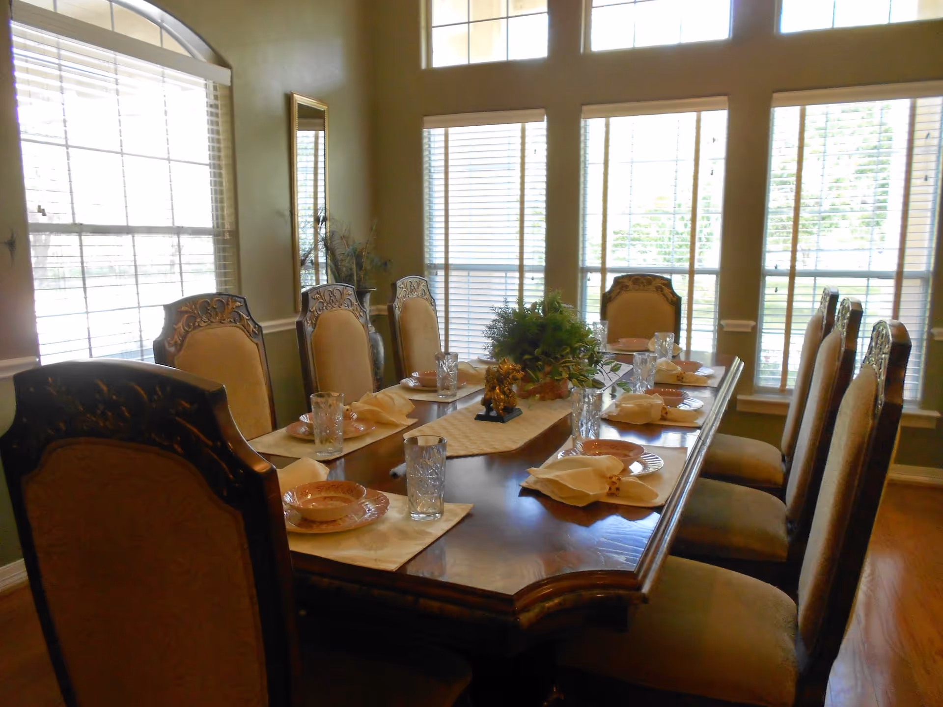 A formal dining room with a long wooden table set for a meal.