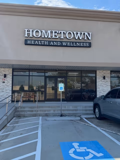 Exterior view of Hometown Health and Wellness building with glass entrance and accessible parking.