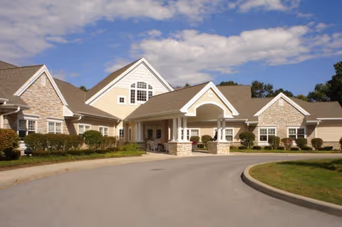 Senior living facility building with a curved driveway and landscaped entry in Clifton Park.