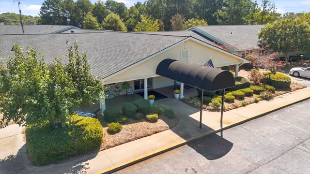 Hart Care Center exterior with curved black awning, landscaped shrubs, and parking.