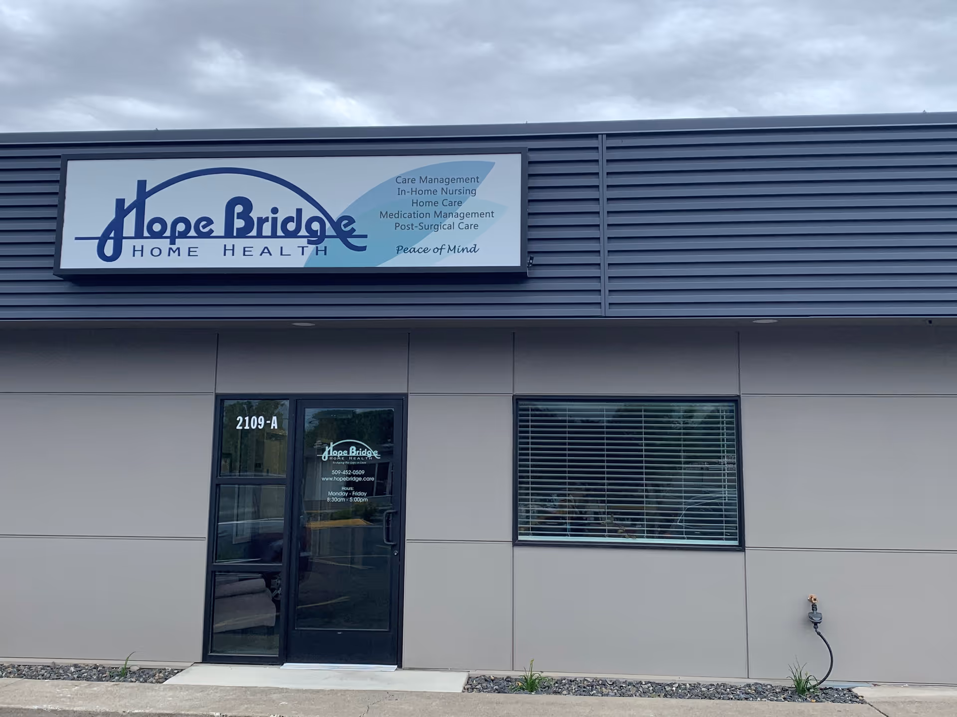 Front view of Hope Bridge Home Health building with sign and glass entrance door.