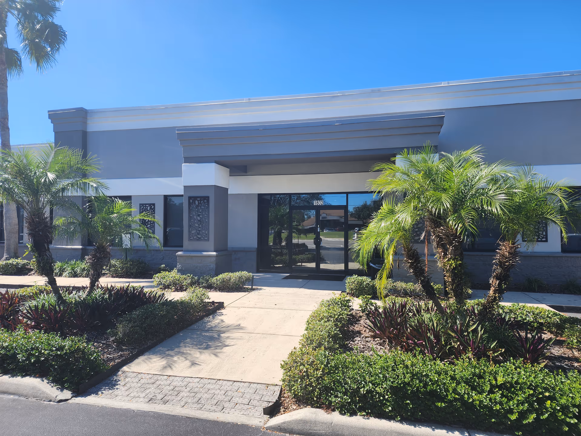 Exterior view of CareBuilders at Home Central and East Orlando entrance with palm landscaping.
