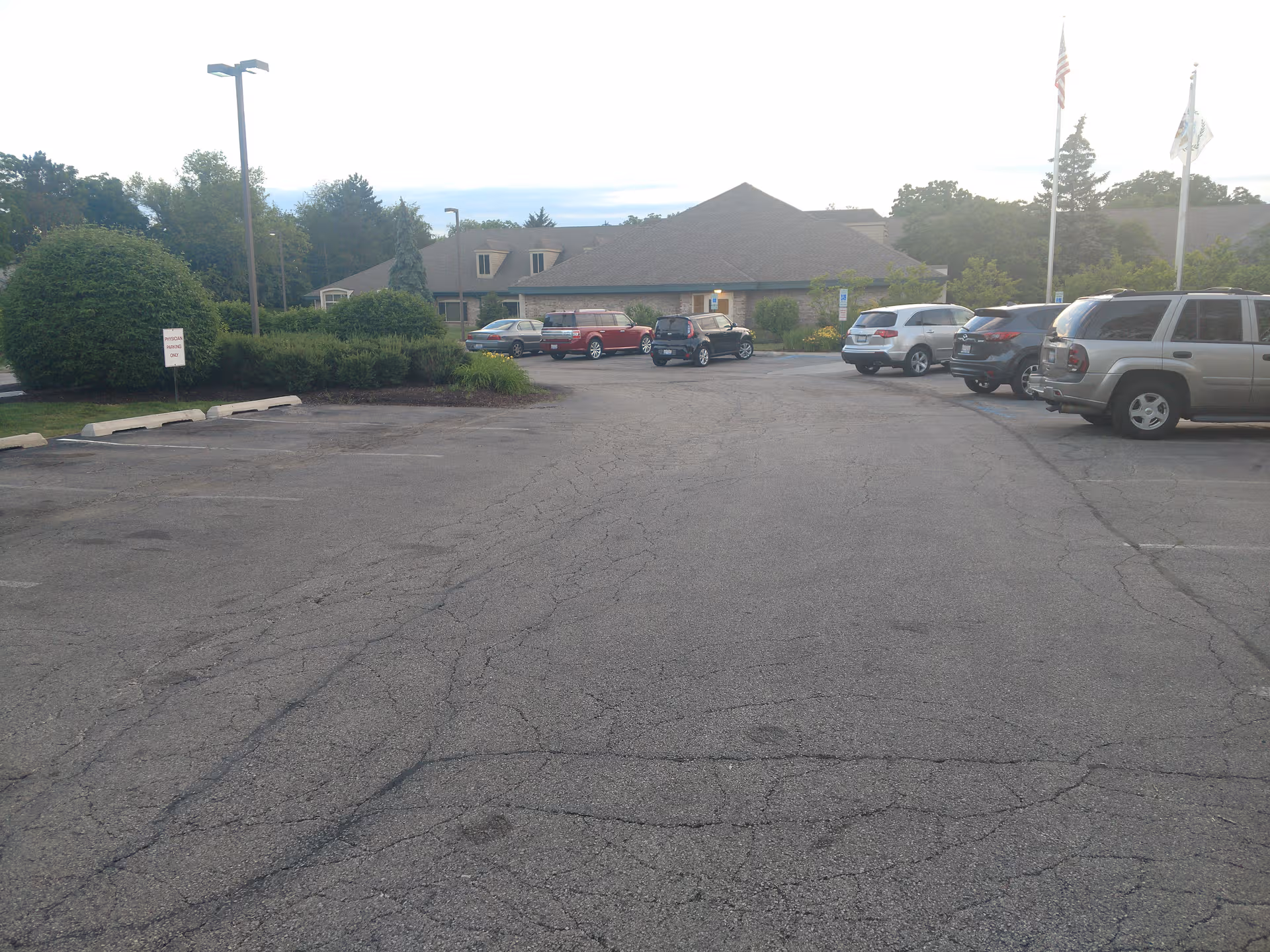 Alden Estates of Barrington exterior with a parking lot and surrounding greenery.