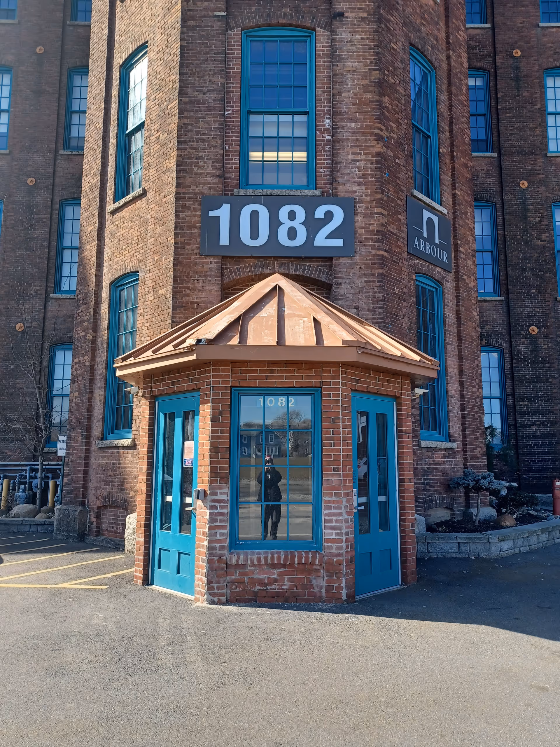 Brick building with teal storefront doors and a copper-roofed front entrance.