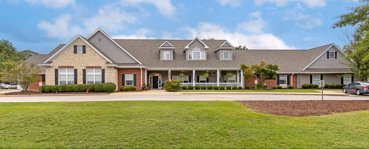 Exterior view of Sumter Terrace Assisted Living building with manicured lawn and entrance.