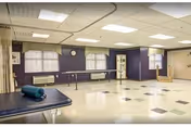 Empty rehabilitation room with purple walls and exercise equipment.