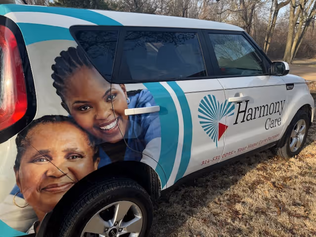 Exterior of a Harmony Care van with large portrait graphics and branding.