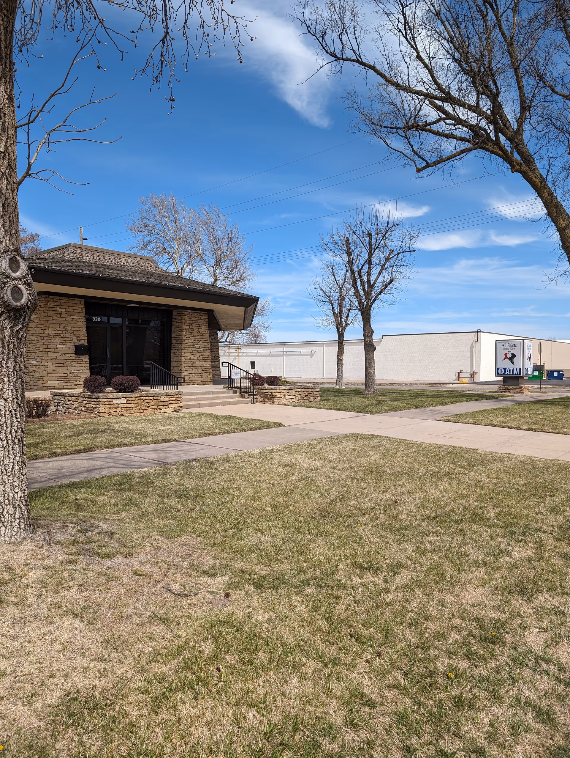 Exterior view of All Saints Home Care building with entrance steps and yard