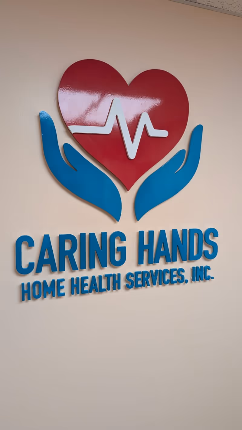 Interior wall sign featuring a red heart, heartbeat line, and blue hands.