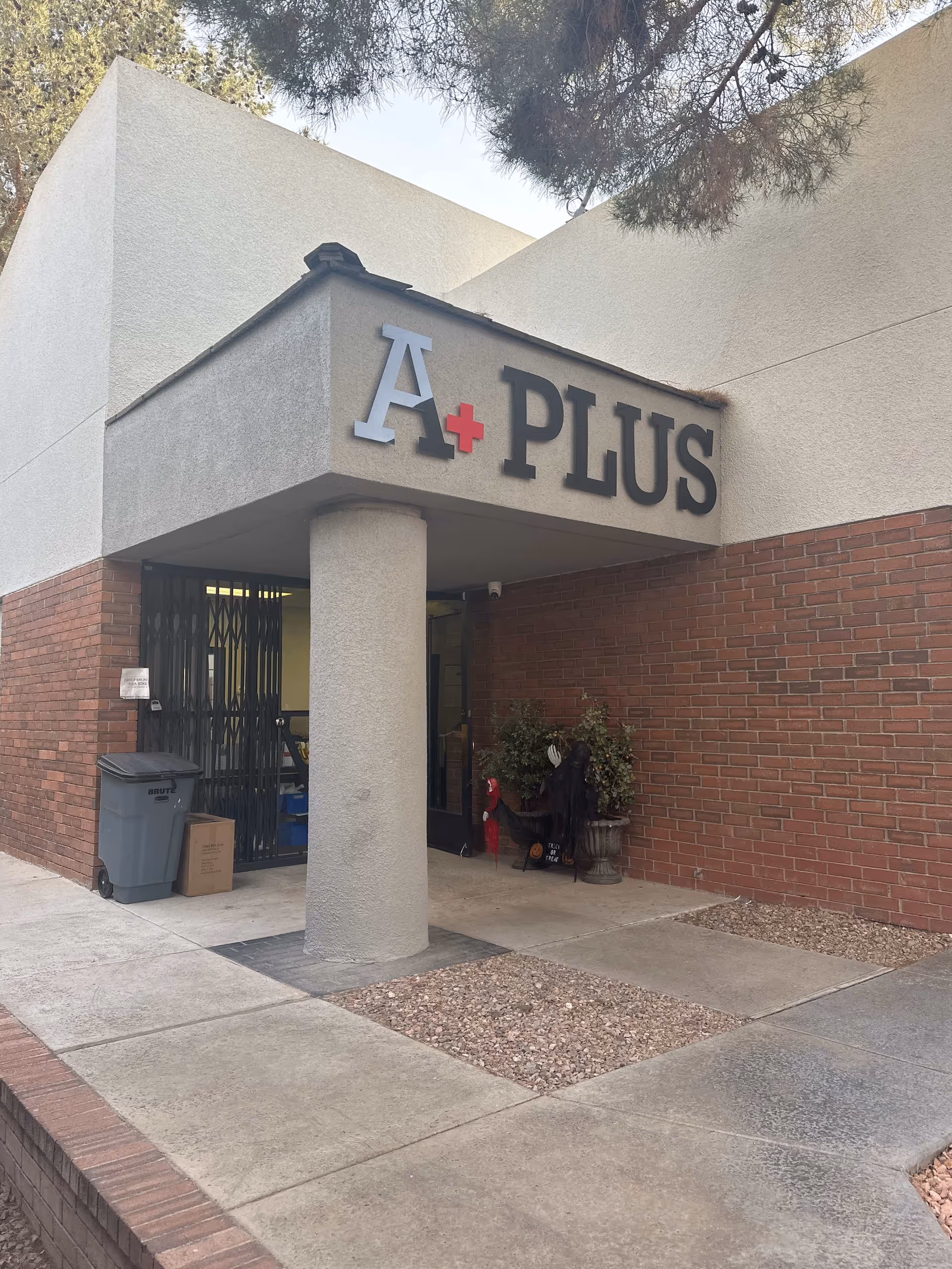 Exterior view of A Plus facility entrance with brick walls and a columned overhang.