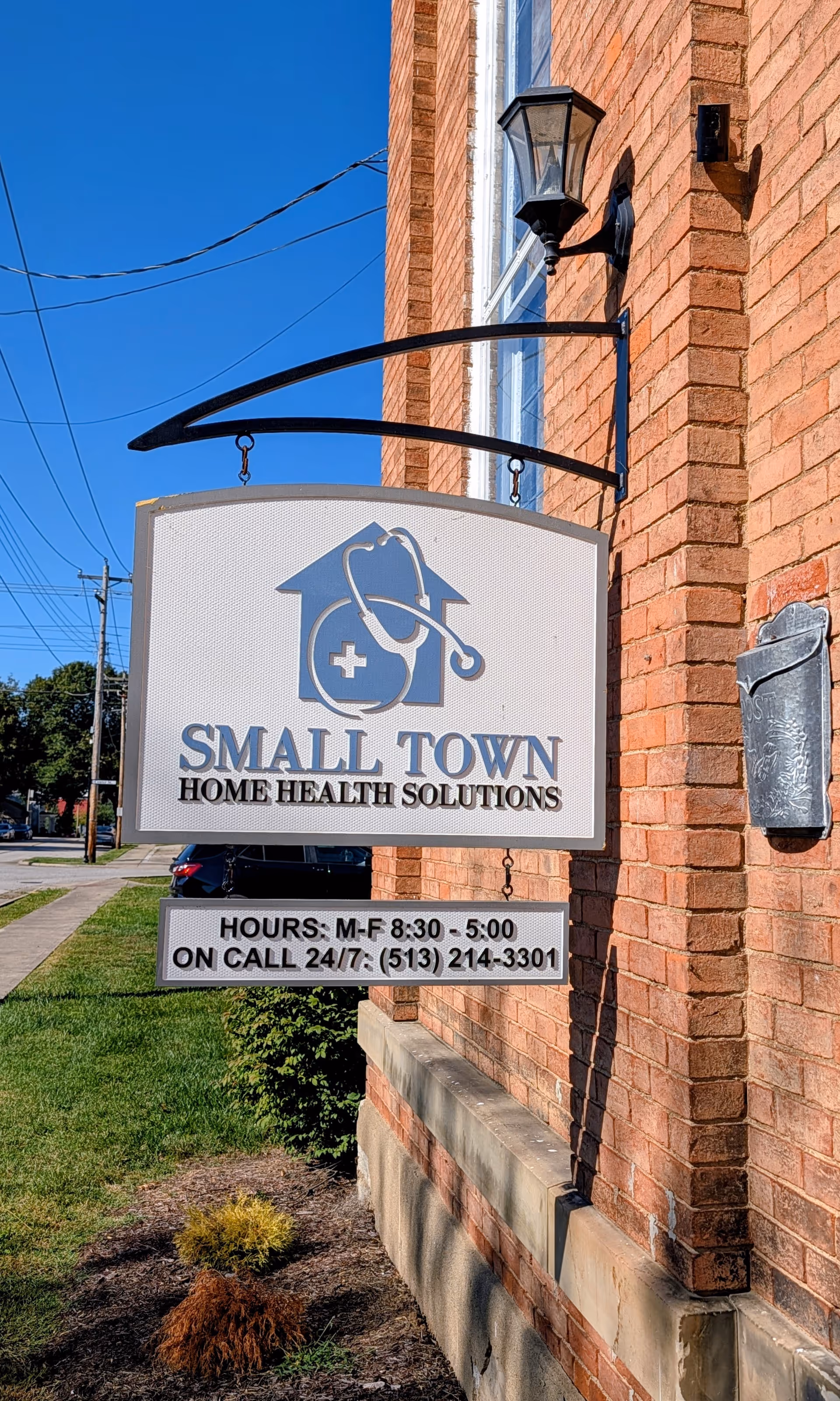 Exterior view of a brick building with a hanging sign for Small Town Home Health Solutions.