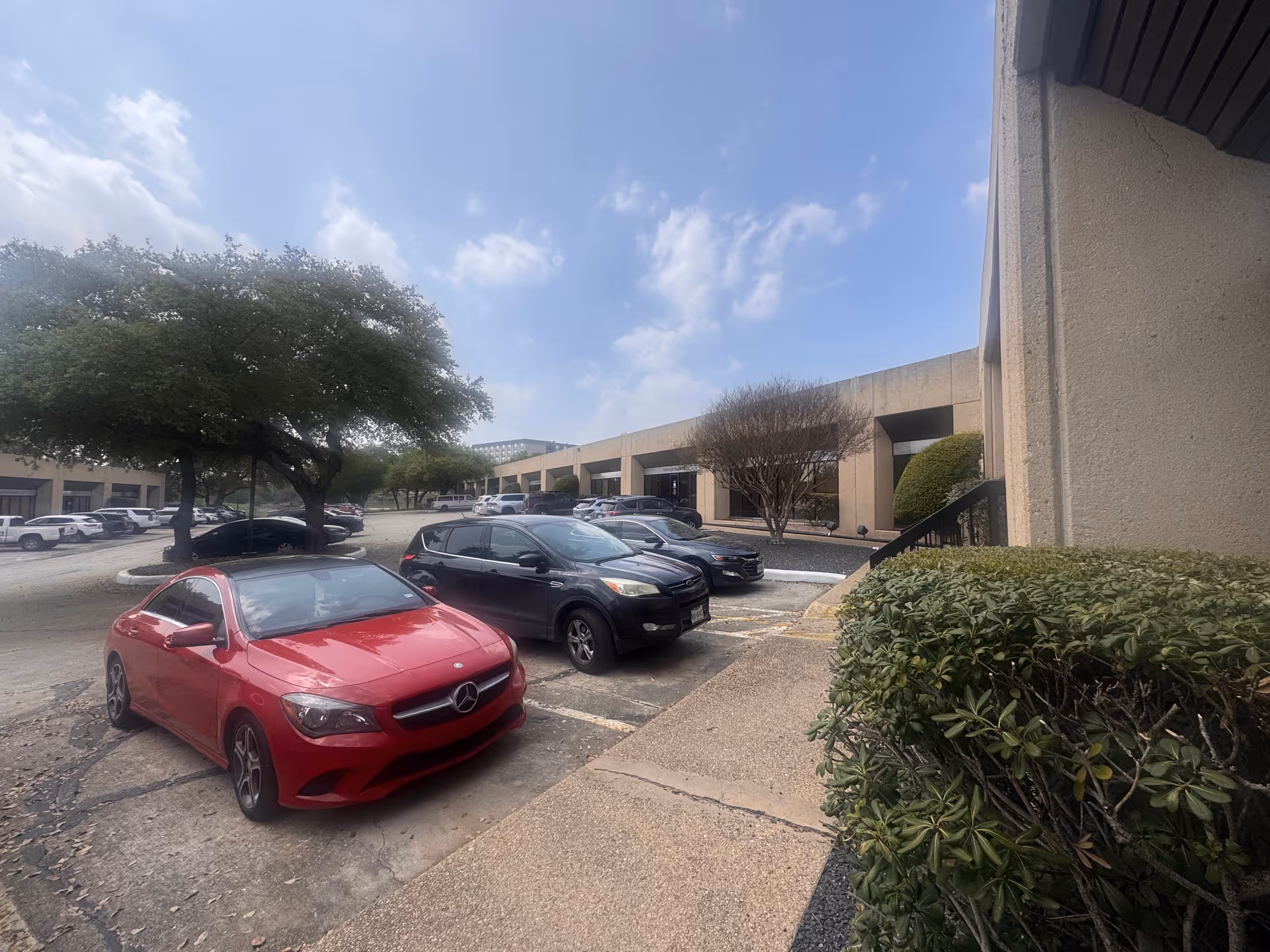 Exterior view of Community Assistance Healthcare Services facility with parked cars and landscaping.