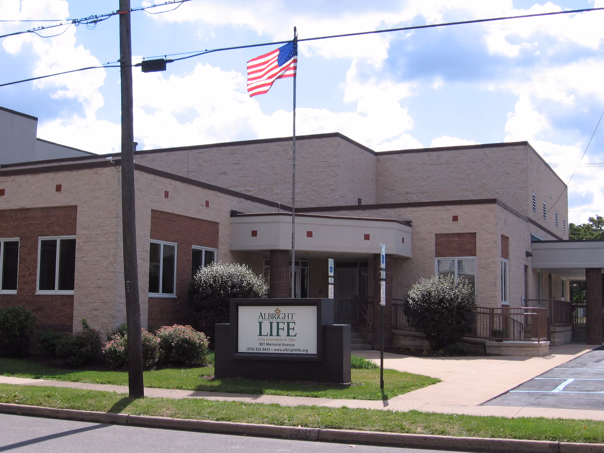 Exterior view of Albright LIFE Lycoming facility with sign and flag