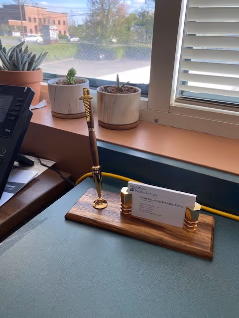 Interior desk at HighPoint Palliative Care with pen, business card holder, and small plants.
