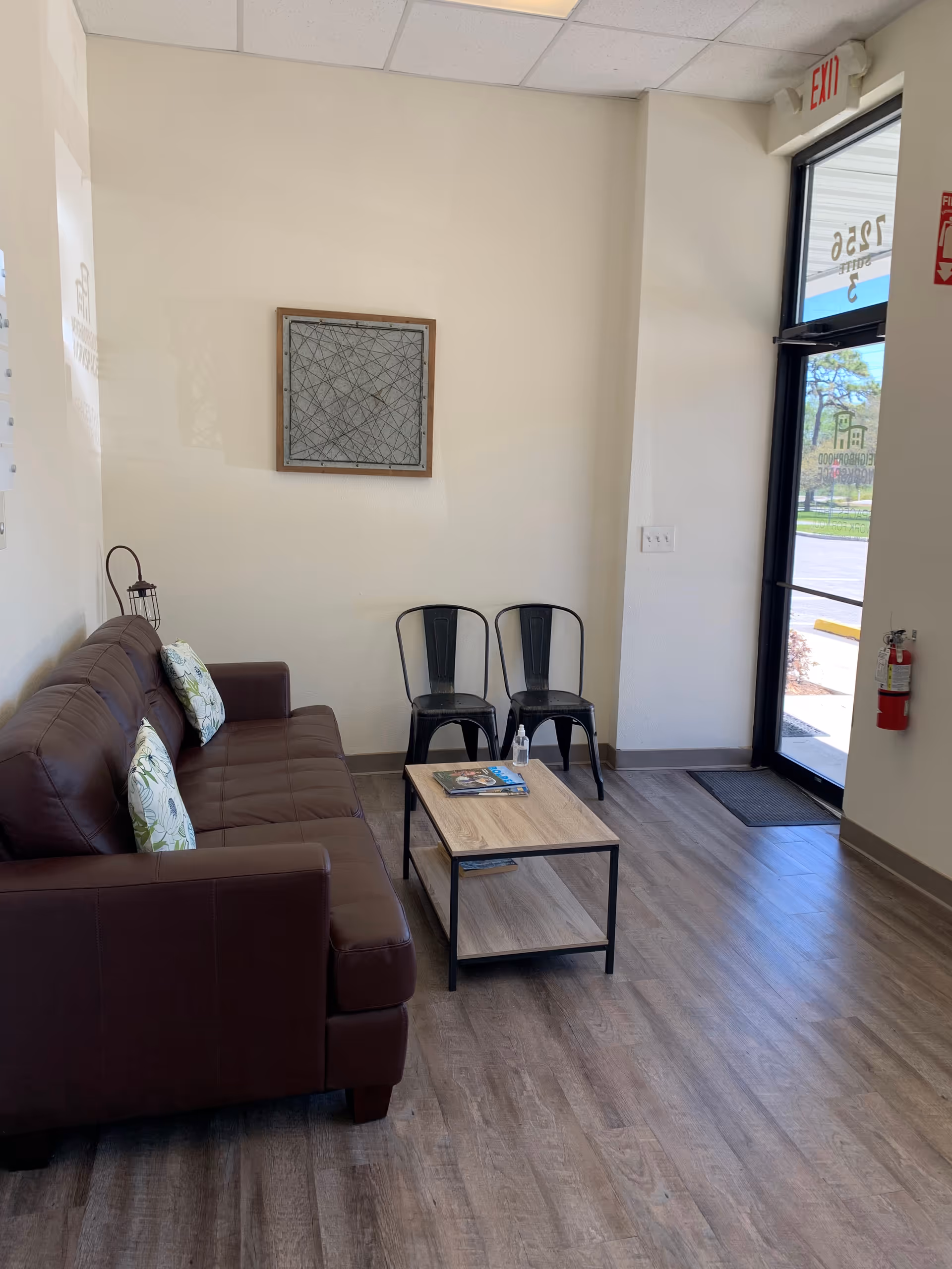 Lobby waiting area inside a senior living facility with sofa, chairs, and a coffee table.