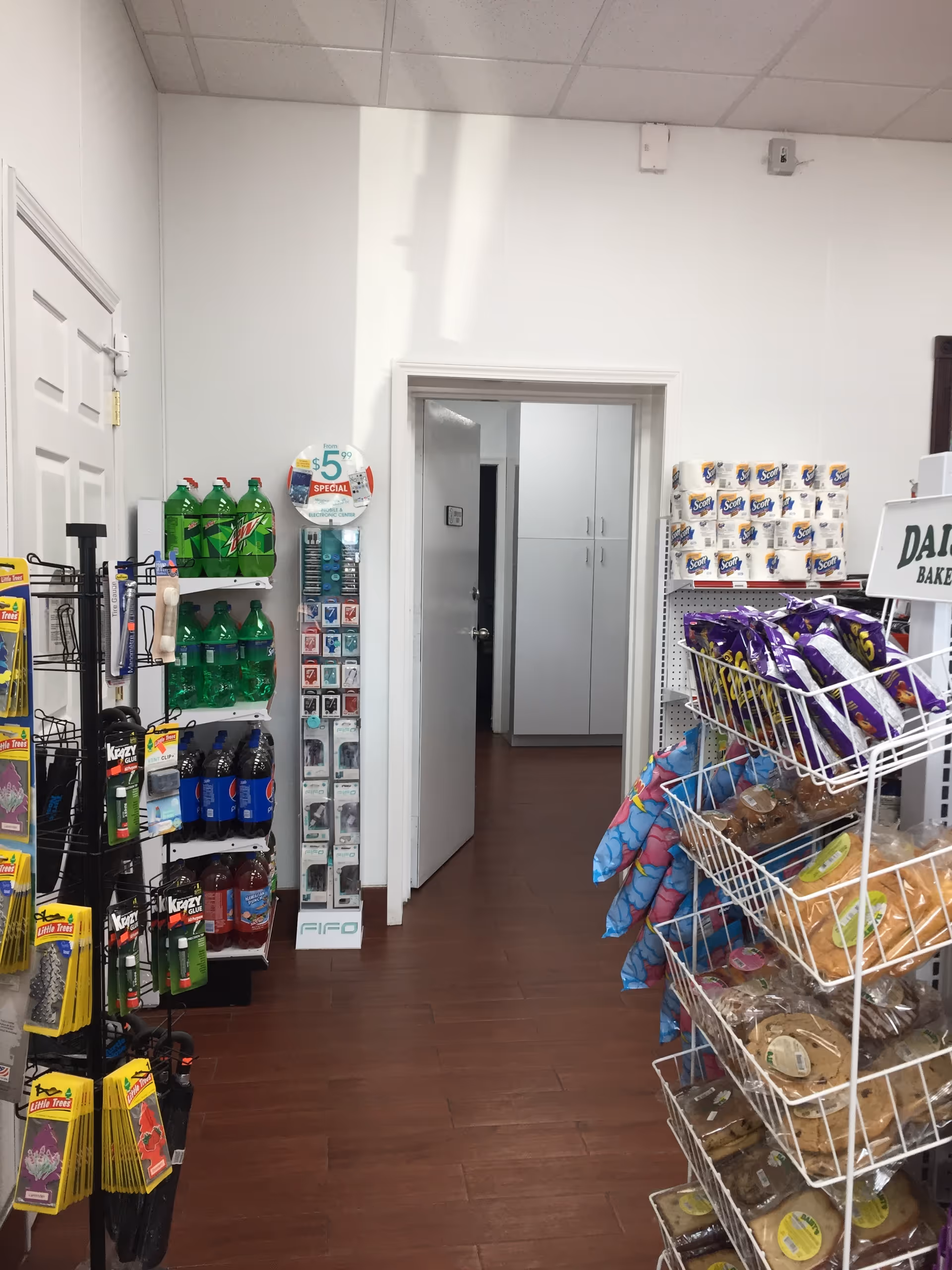 Interior store aisle inside a senior living facility with snacks, drinks, and a doorway.