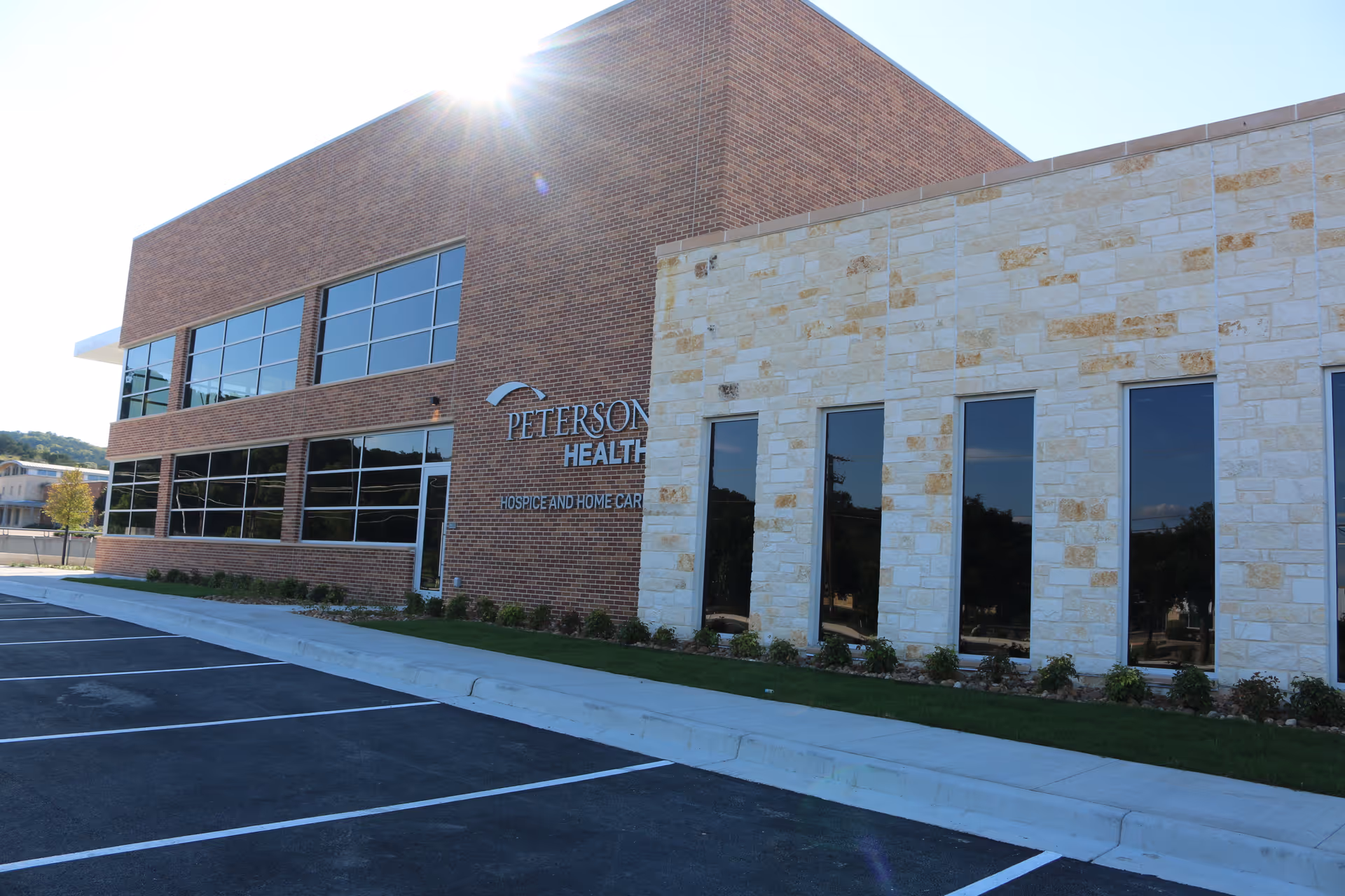 Front exterior of Peterson Health facility with brick and stone facade and large windows