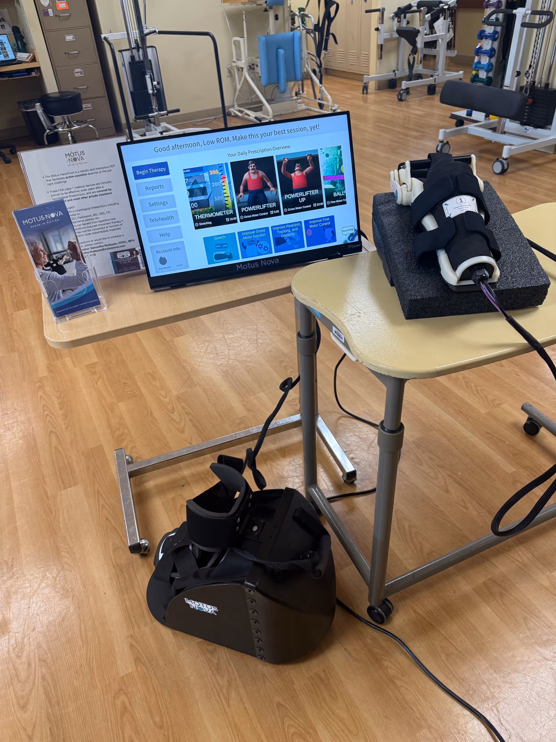 Rehabilitation therapy station with a Motus Nova monitor and exercise equipment in a clinic.