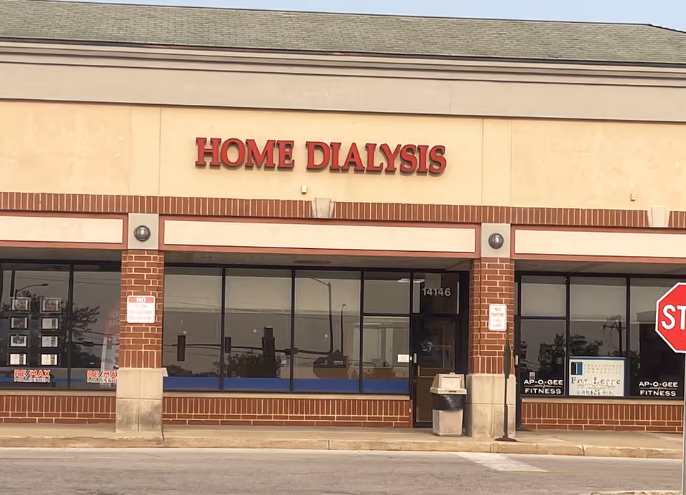 Exterior view of a brick storefront reading Home Dialysis with large windows and entrance.