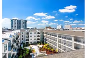 Aerial view of a modern senior living campus courtyard with white buildings and blue sky.