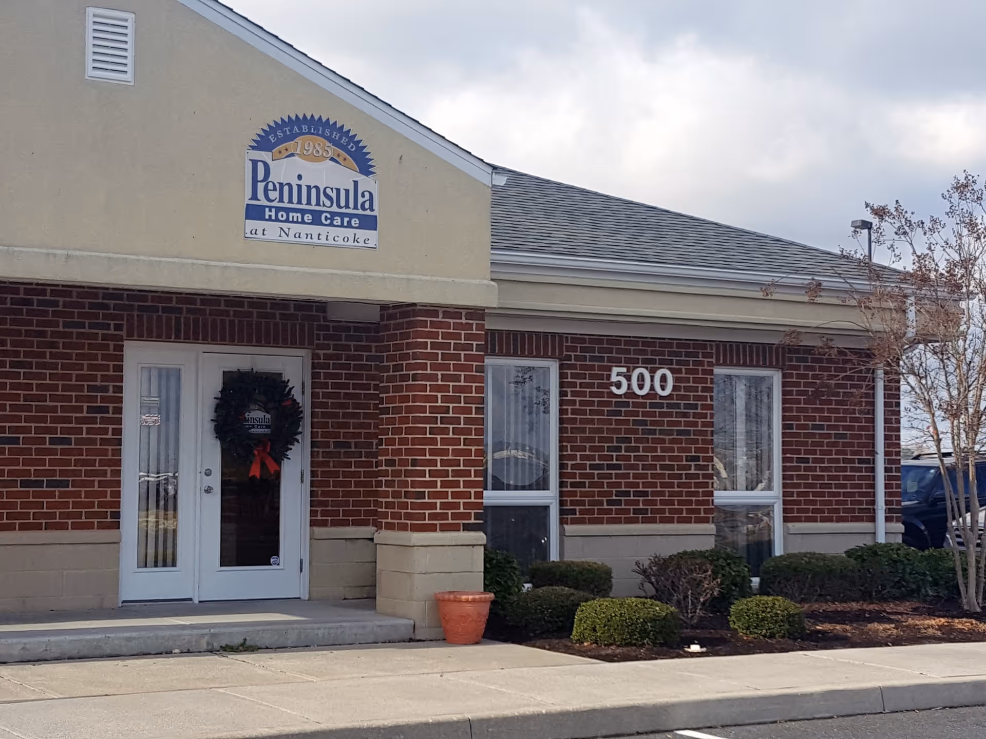 Front exterior of Peninsula Home Care at Nanticoke with brick facade and sign.