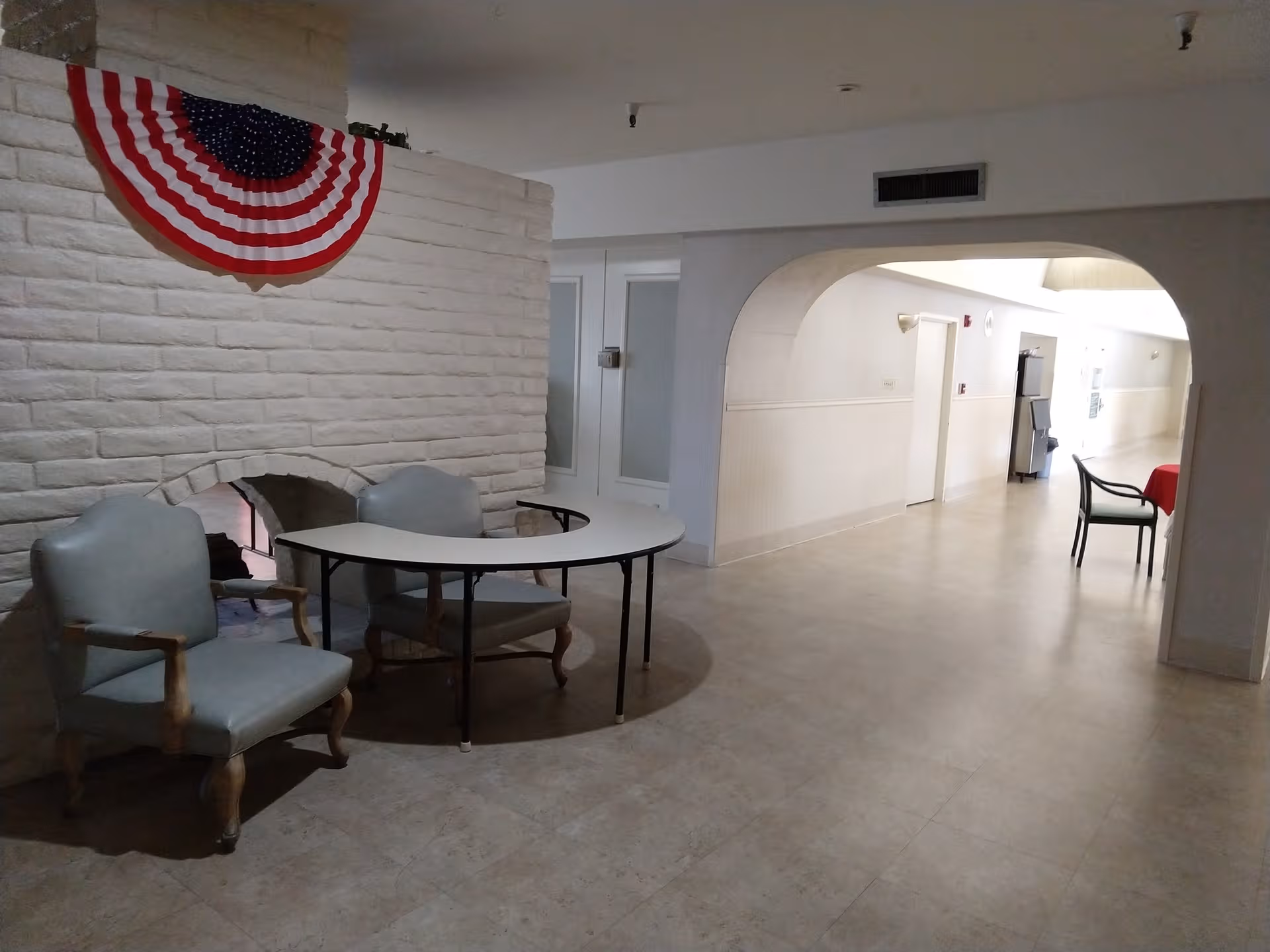Lobby area with pale seating and patriotic bunting along a brick wall.