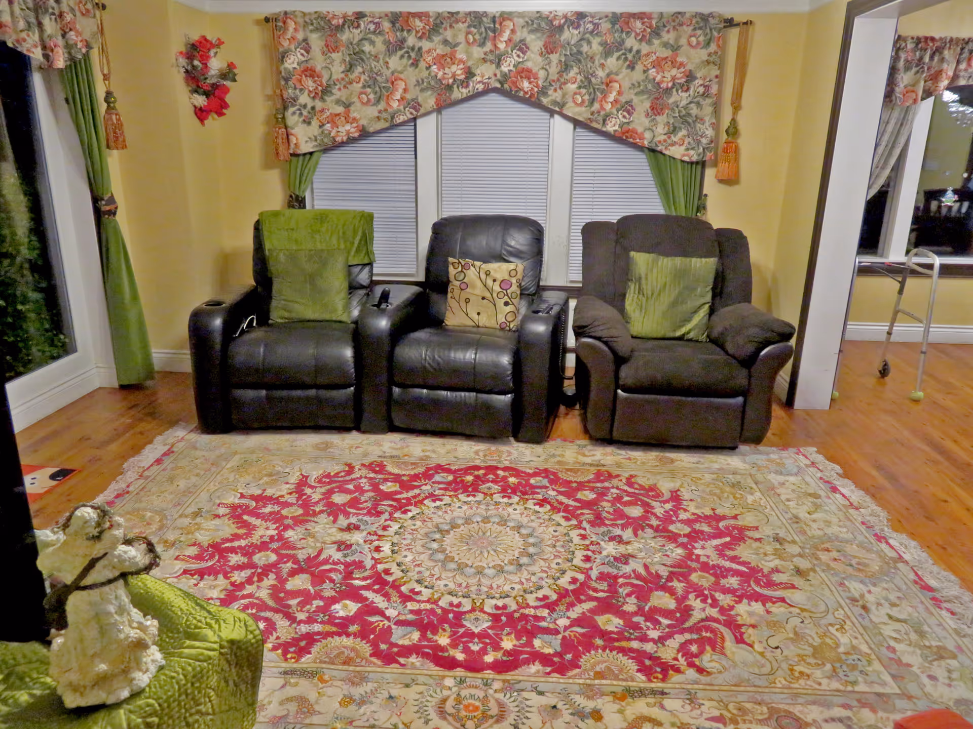 Three recliner chairs in a living room with a large ornate floral rug.