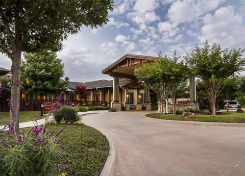 Exterior view of Sunrise of Fort Worth senior living facility with entrance canopy and landscaped grounds