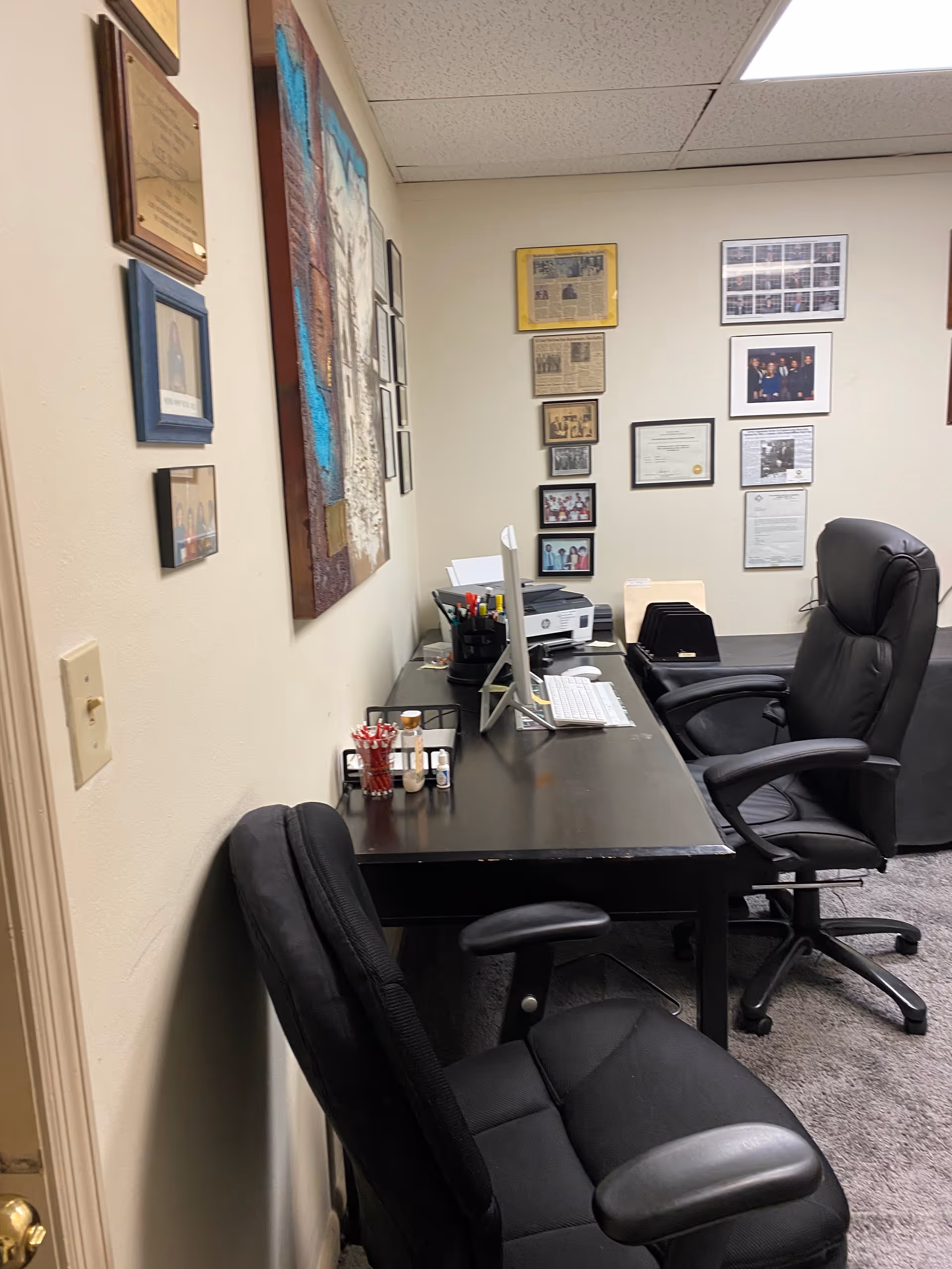 Office workspace inside a senior care facility with desk, computer, and framed certificates.