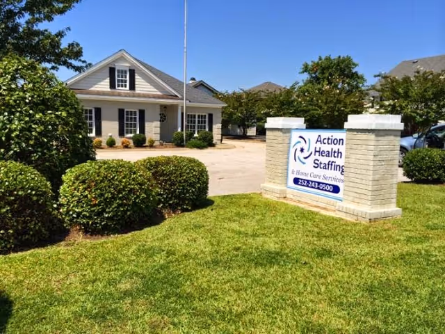 Exterior view of a senior living building with an Action Health Staffing sign.