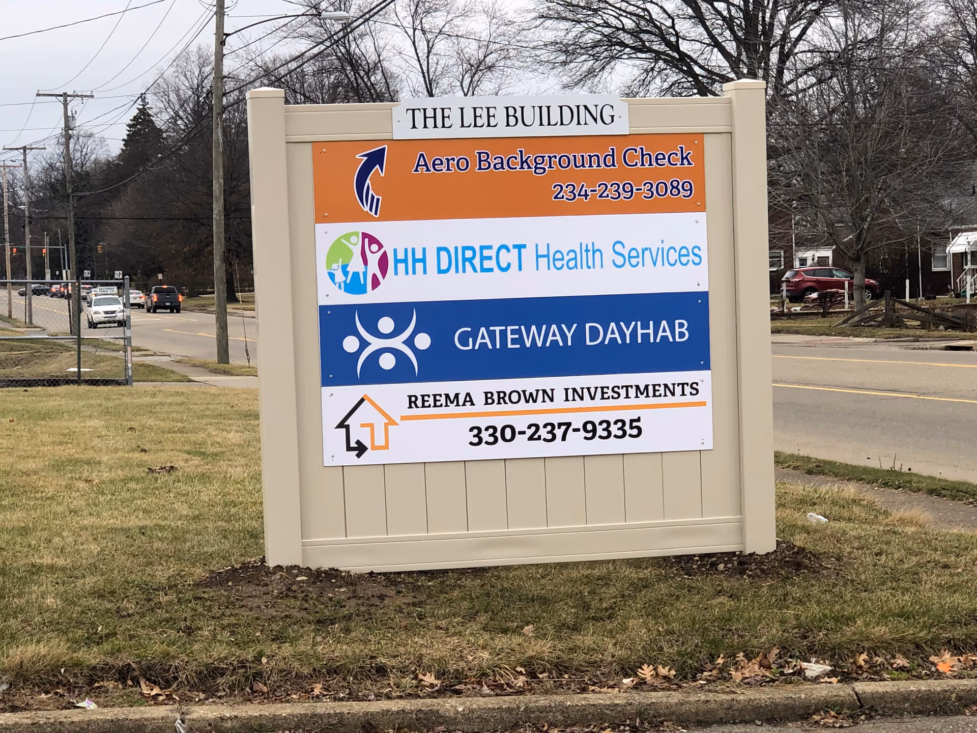 Large outdoor signboard displays HH Direct Health Services among other business banners.
